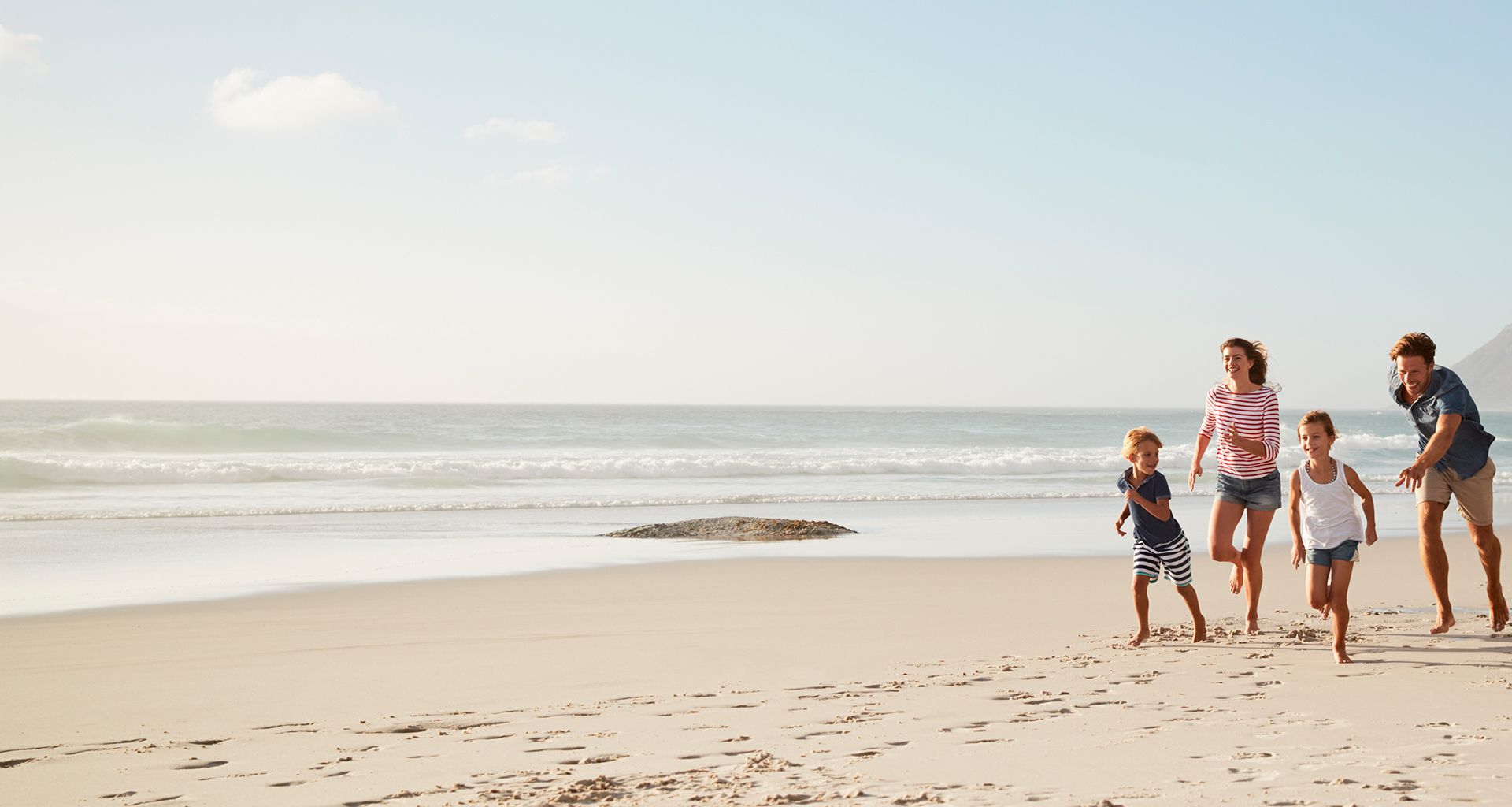 family running on a sandy beach