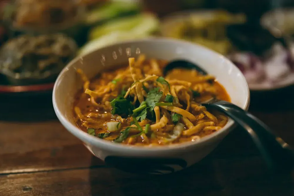 A bowl of Khao Soi curry noodles topped with crispy noodles
