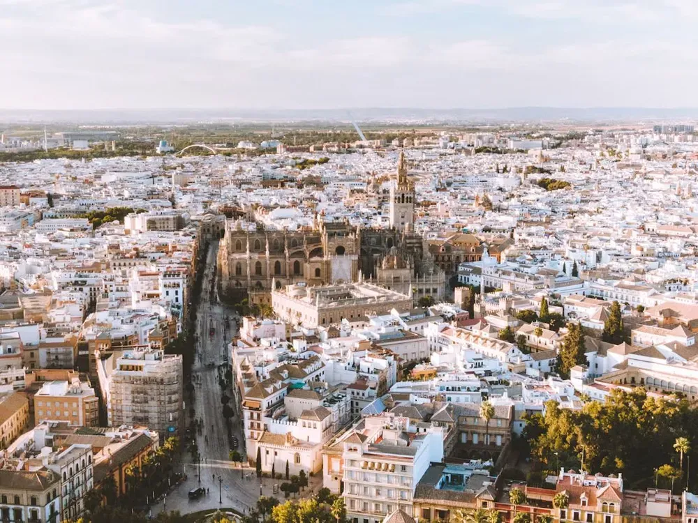 An aerial view of Seville with the cathedral's spire towering over the other buildings