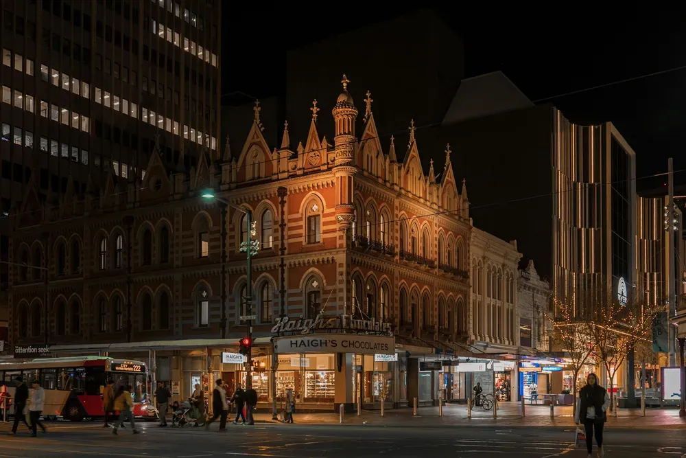 Das historische Gebäude Beehive Corner in Adelaide, Australien, an der Kreuzung von King William Street und Rundle Mall bei Nacht.
