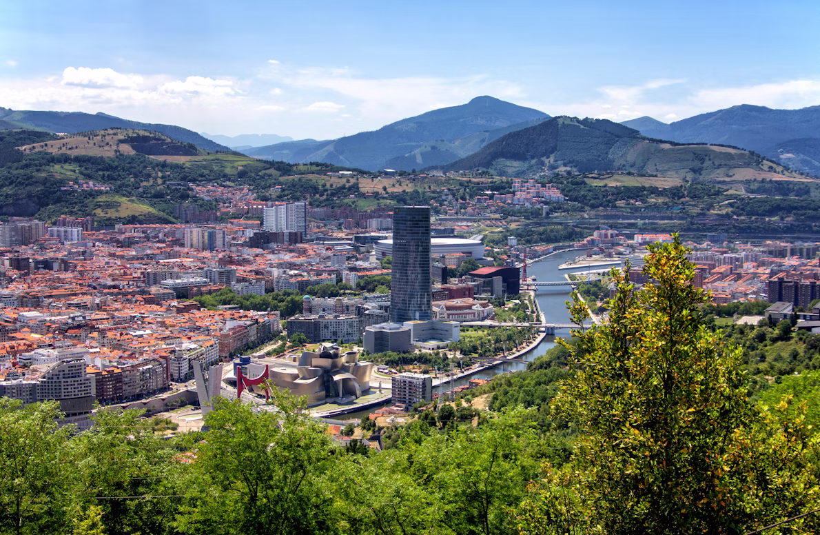 Eine Panoramaaufnahme aus der Luft zeigt die Stadt Bilbao in Spanien, durch die sich ein Fluss schlängelt.