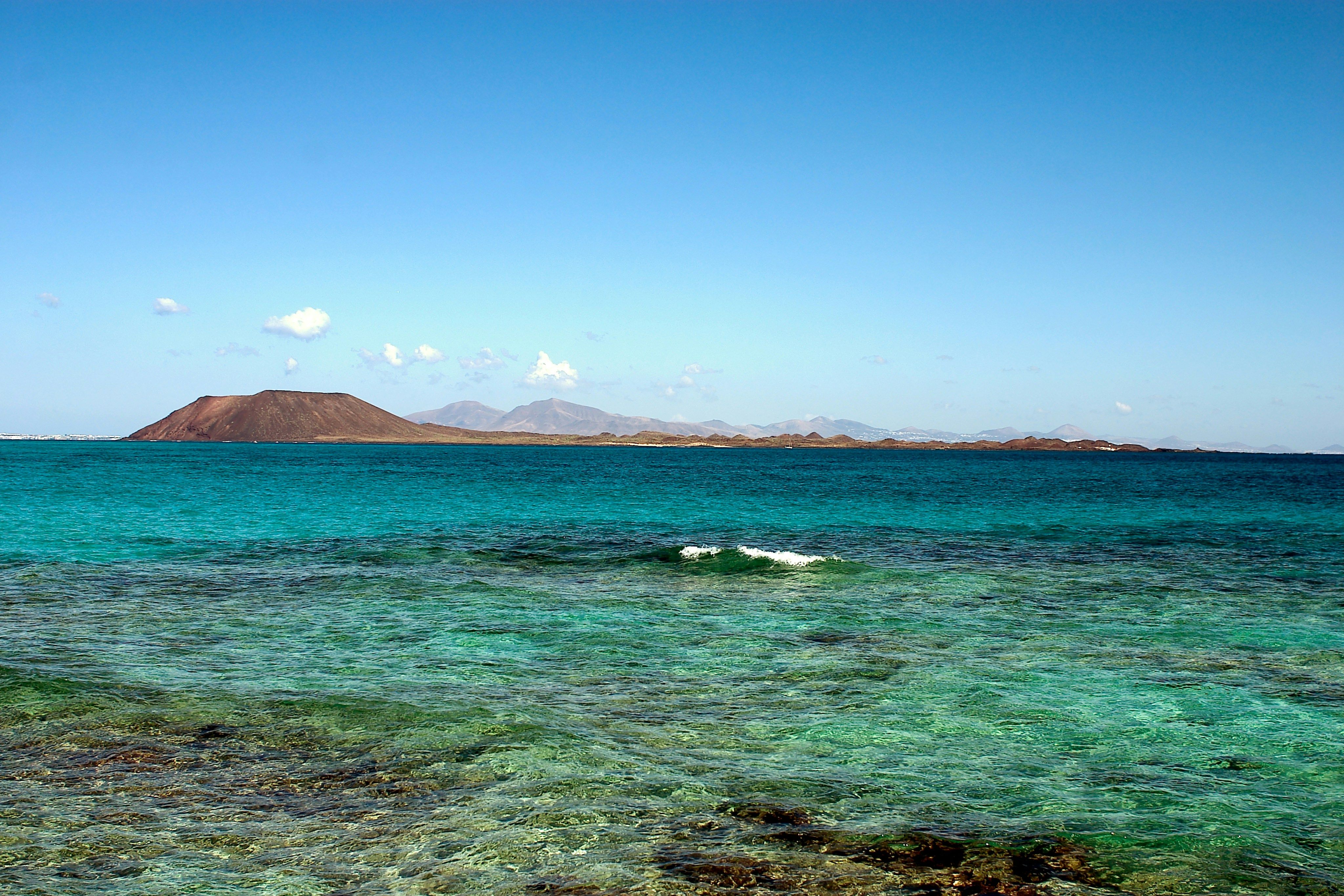 Am Horizon hinter dem blauen Meer erkennt man die Vulkaninsel Lobos. Das Foto wurde von Corralejo aus aufgenommen.