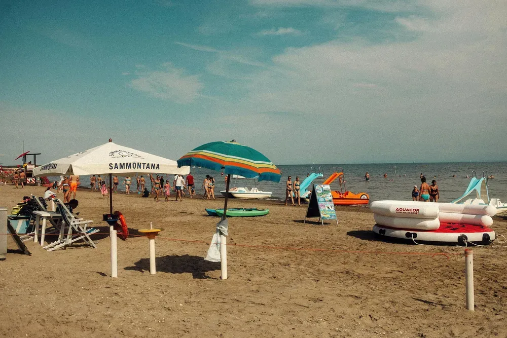Ein typisch italienischer Sandstrand mit Sonnenschirmen in Caorle, Venetien.