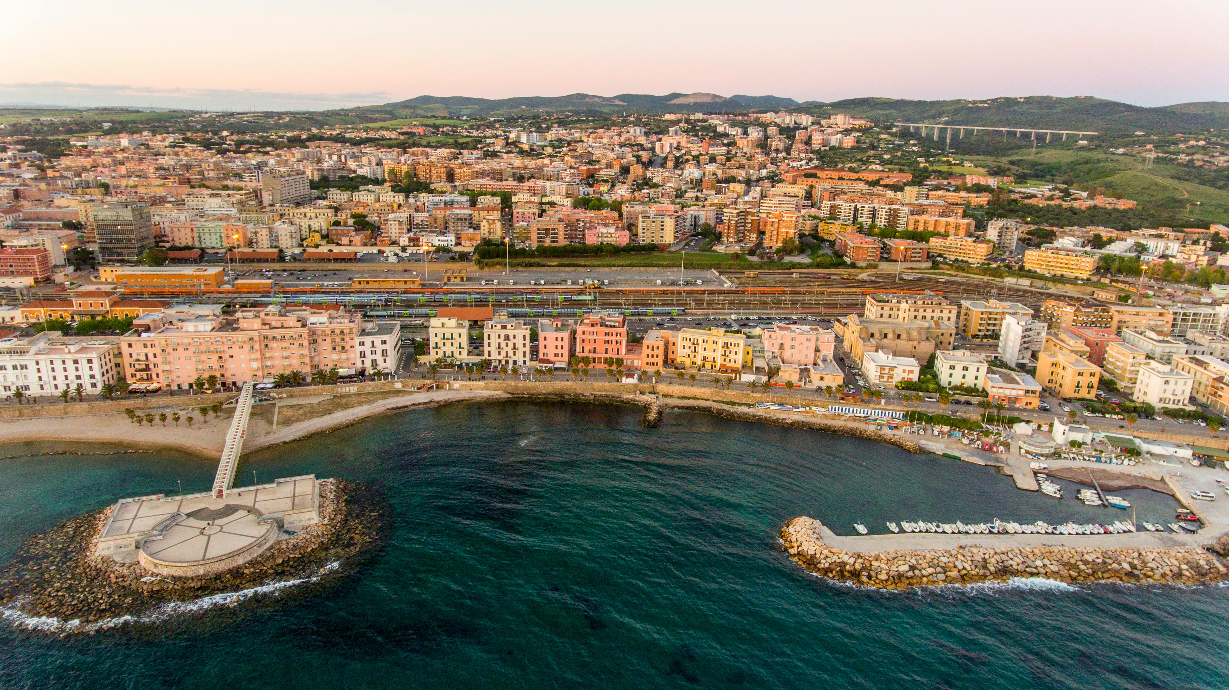 Das Stadtbild von Civitavecchia, mit seiner Bucht und Hafen, liegt ruhig während der Golden Hour am Meer.