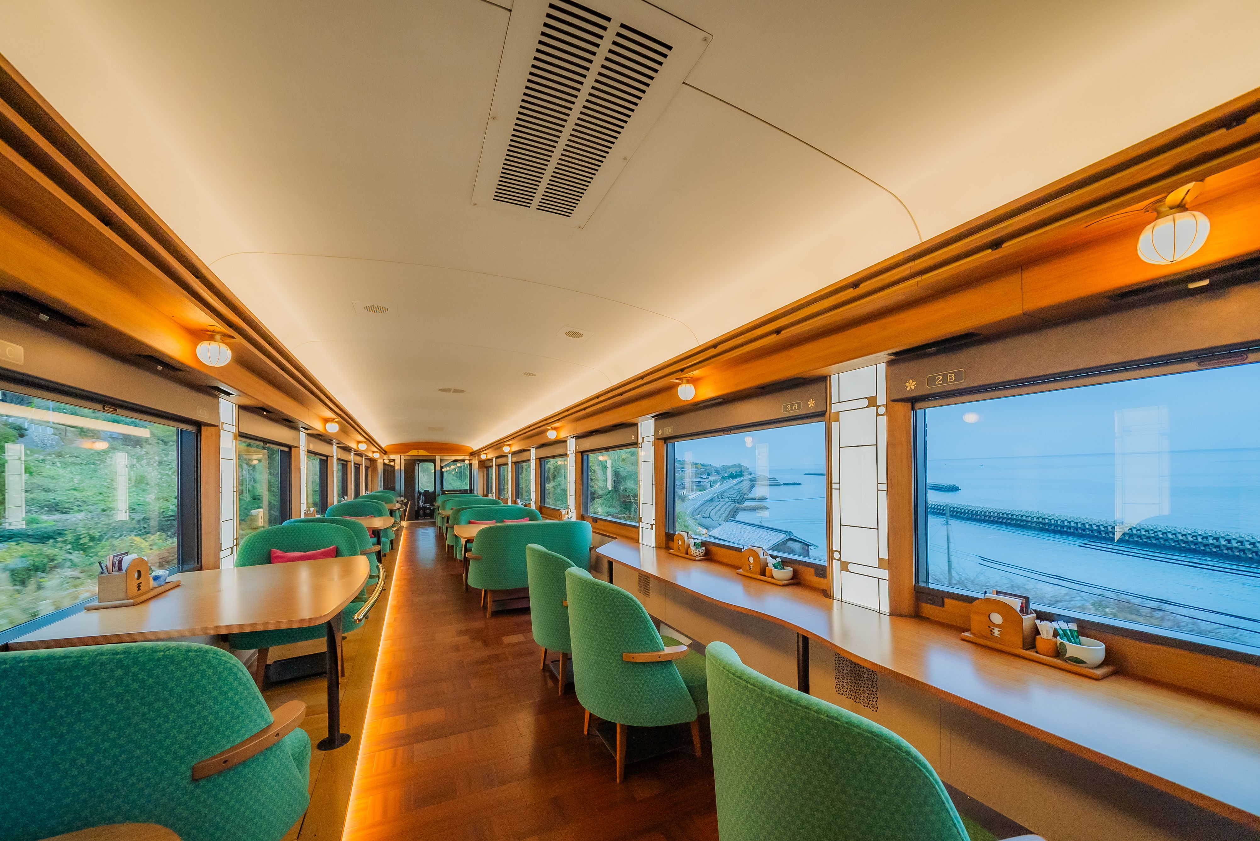Sitting area inside a ferry with windows showing the ocean.
