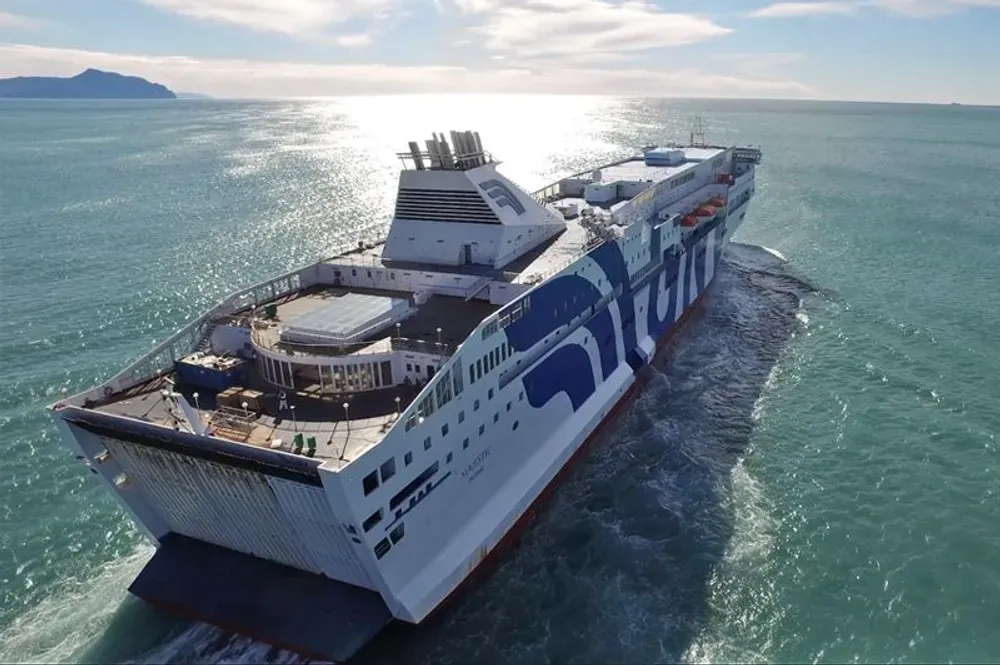 Eine Fähre von Grandi Navi Veloci gleitet im Sonnenschein über das ruhige Meer.