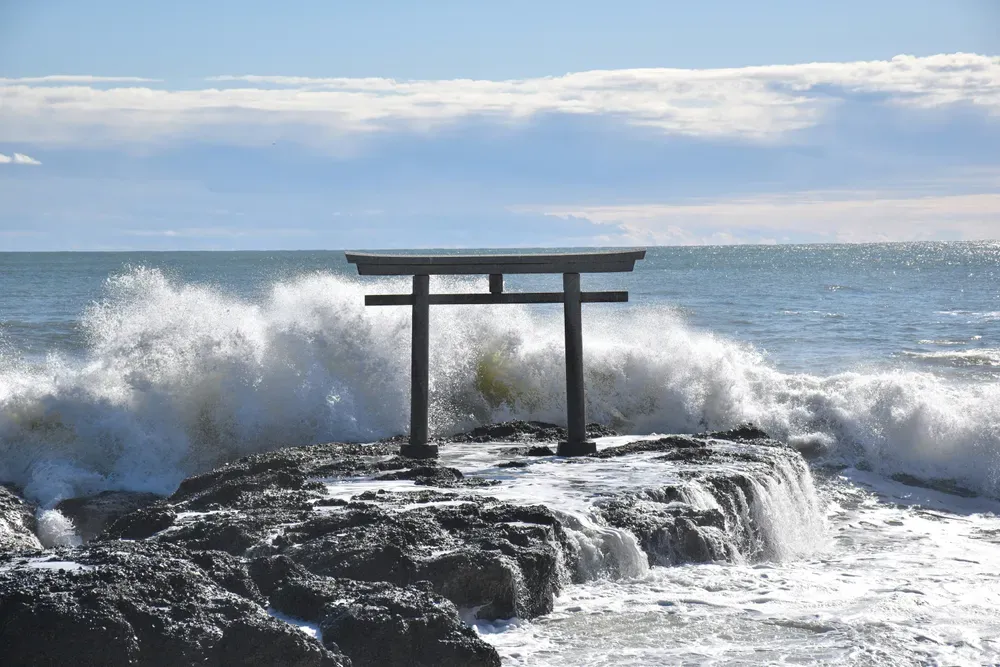 Der Isohamacho-Tempel in Oarai, Japan, steht auf einem kleinen Felsen, an dem sich die tosenden Wellen des Meeres brechen.