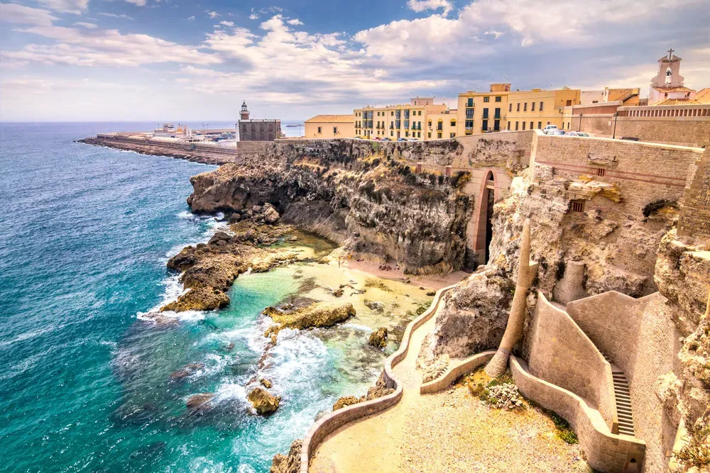Die Sandtöne der historischen und zerklüfteten Küstenlandschaft von Melilla stehen im Kontrast mit dem türkisblauen Meer.