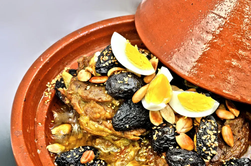Ein traditionelles marokkanisches Gericht, Lamm Tajine mit Datteln, Mandeln und gekochtem Ei, wird in einem traditionellen Gefäß serviert.