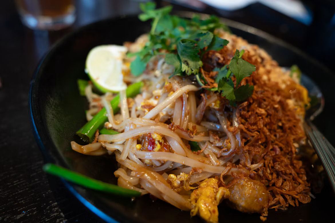 Pad Thai Noodles with chicken, roasted garlic, peanuts, green onions, cilantro and eggs
