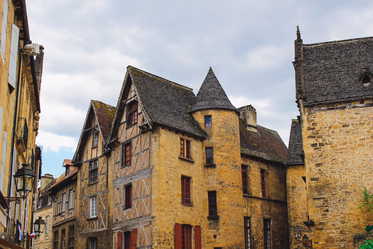Die alten Fachwerkhäuser von Sarlat-la-Canéda sind in gelblichem Stein mit typisch grauen Schieferdächern.