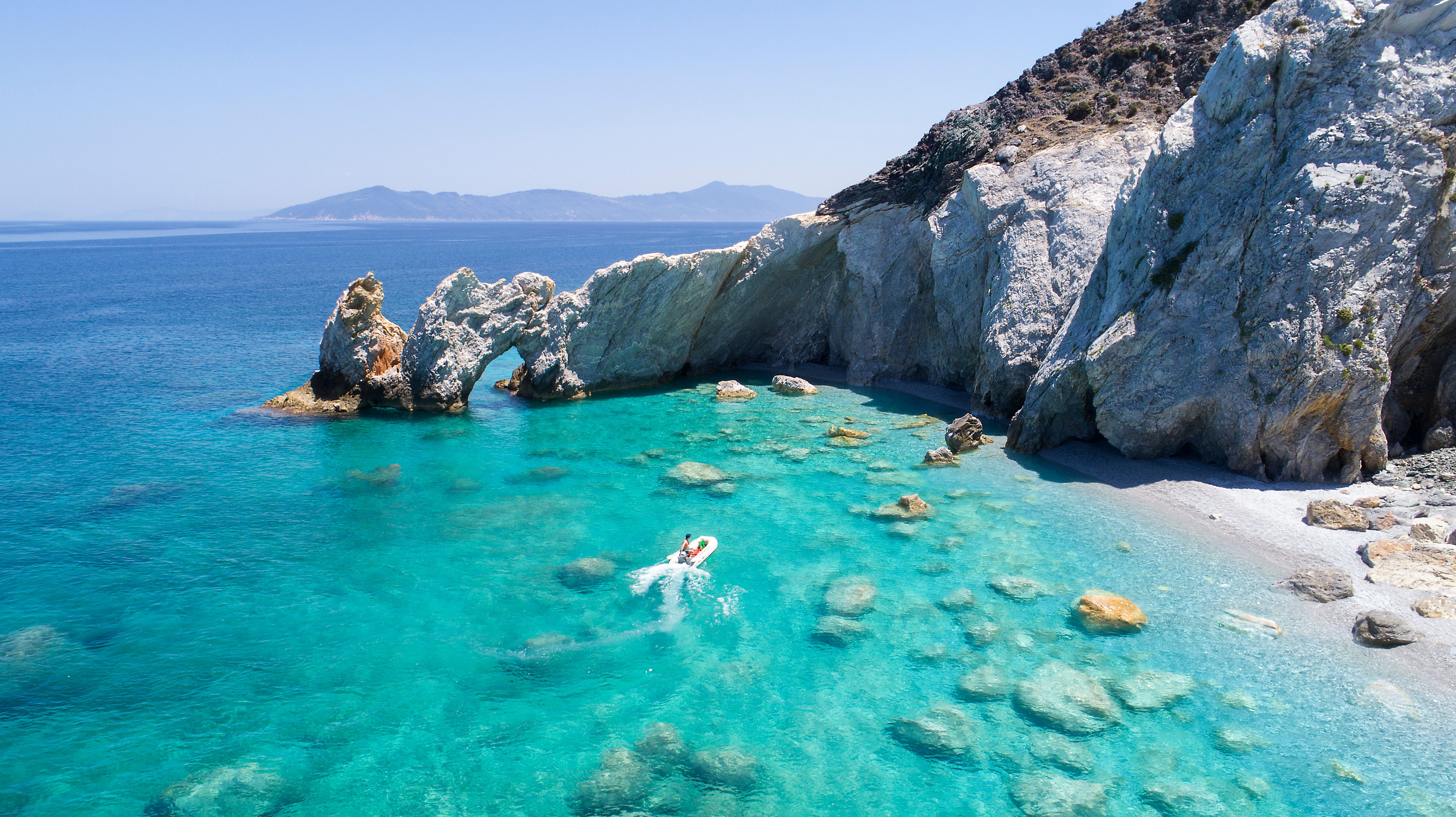 boat by a rocky bay in Skiathos