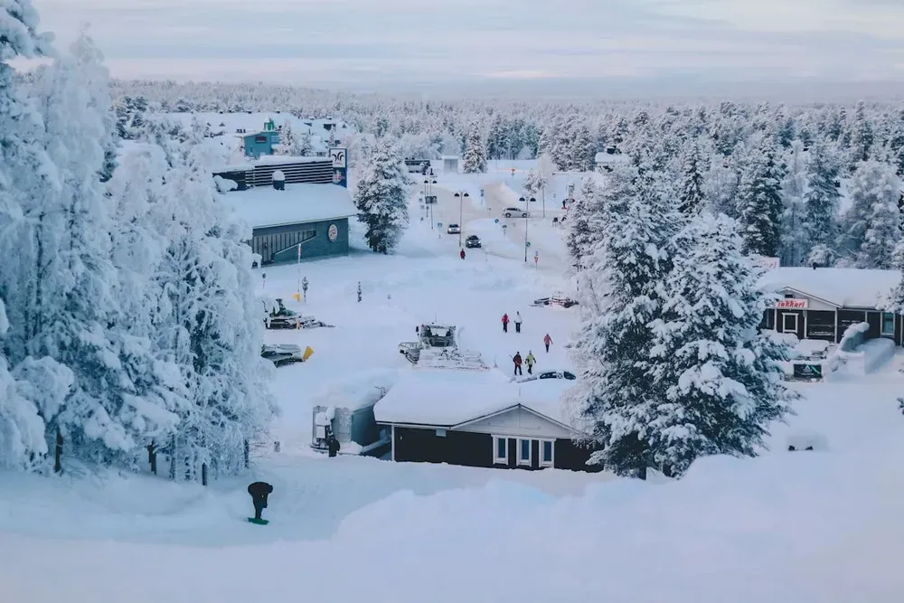 The trees and buildings of Lapland covered in many inches of thick snow