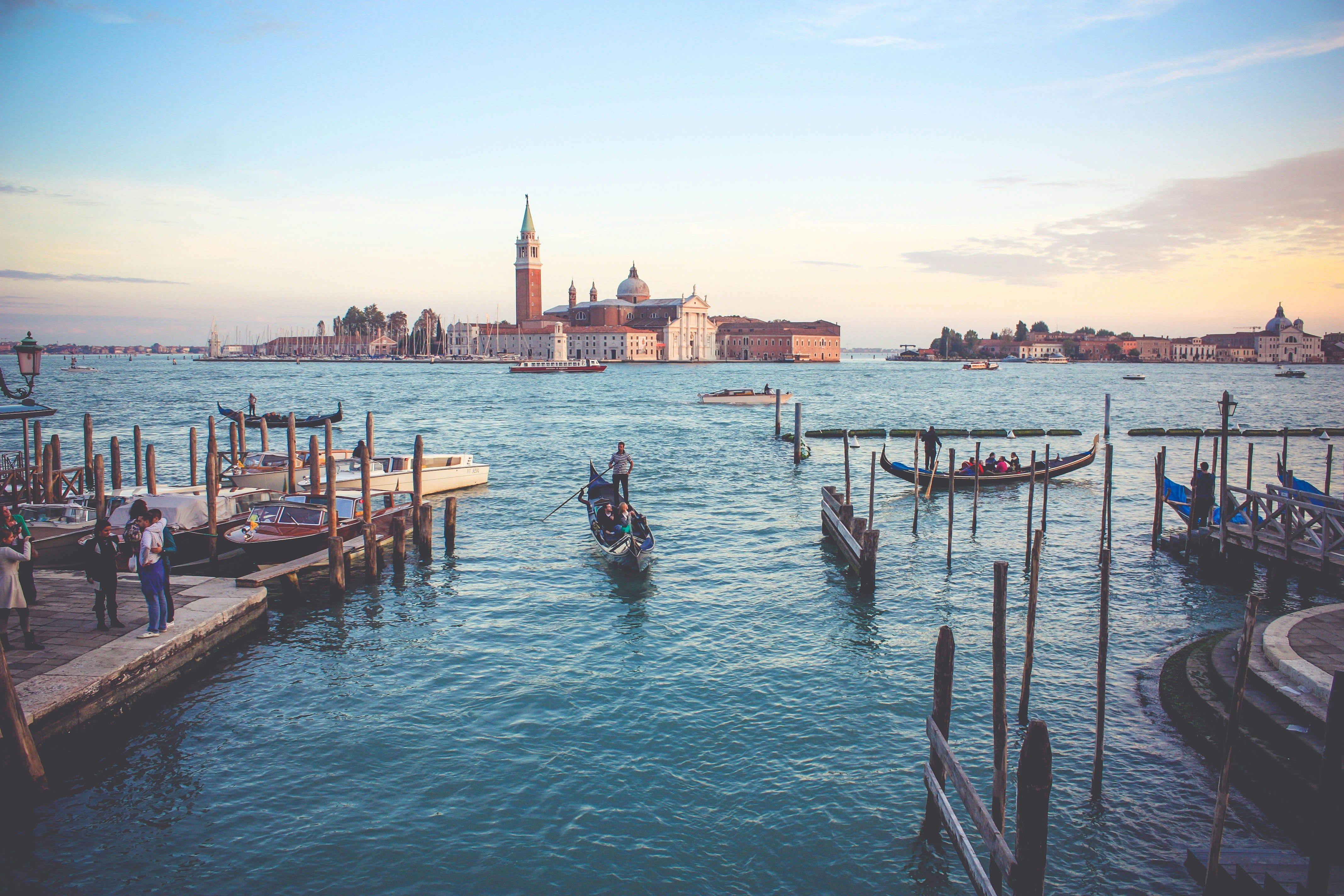 Ein Blick auf Venedig, man sieht viel Wasser und ein paar der berühmten Gondeln, im Hintergrund die Altstadt.