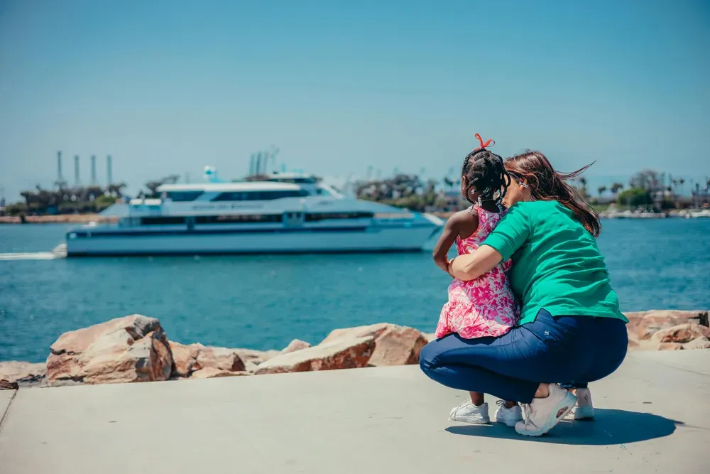 a woman and a child looking at a ferry