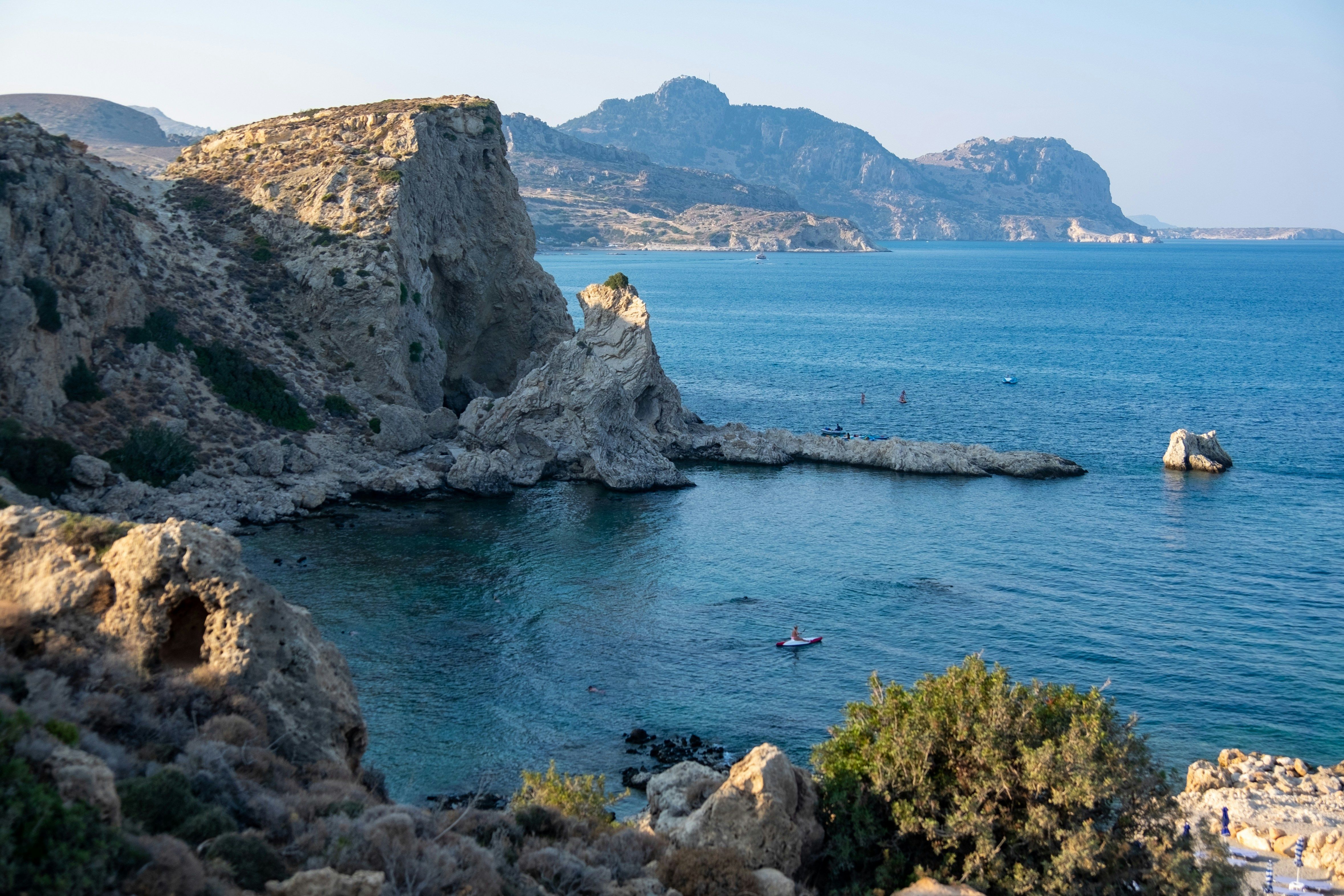 person kayaking in a rocky bay in Rhodes