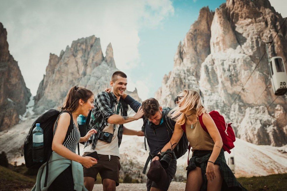 Grupo de amigos jóvenes con mochilas disfrutando de una excursión en la montaña