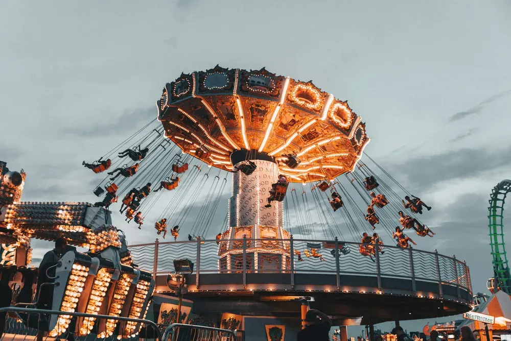 amusement park swing ride lit up at night.webp