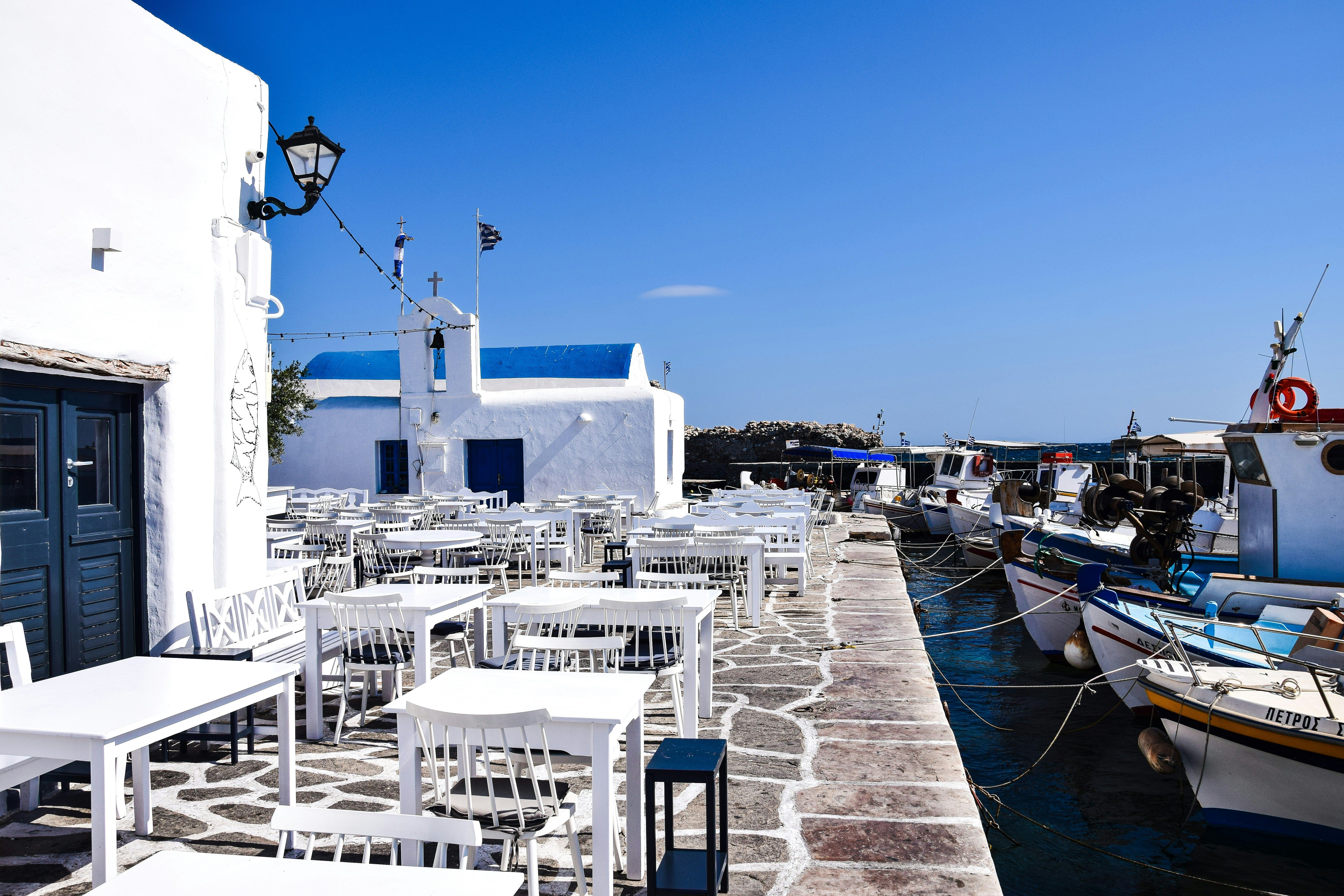 white tables next to the water in Paros