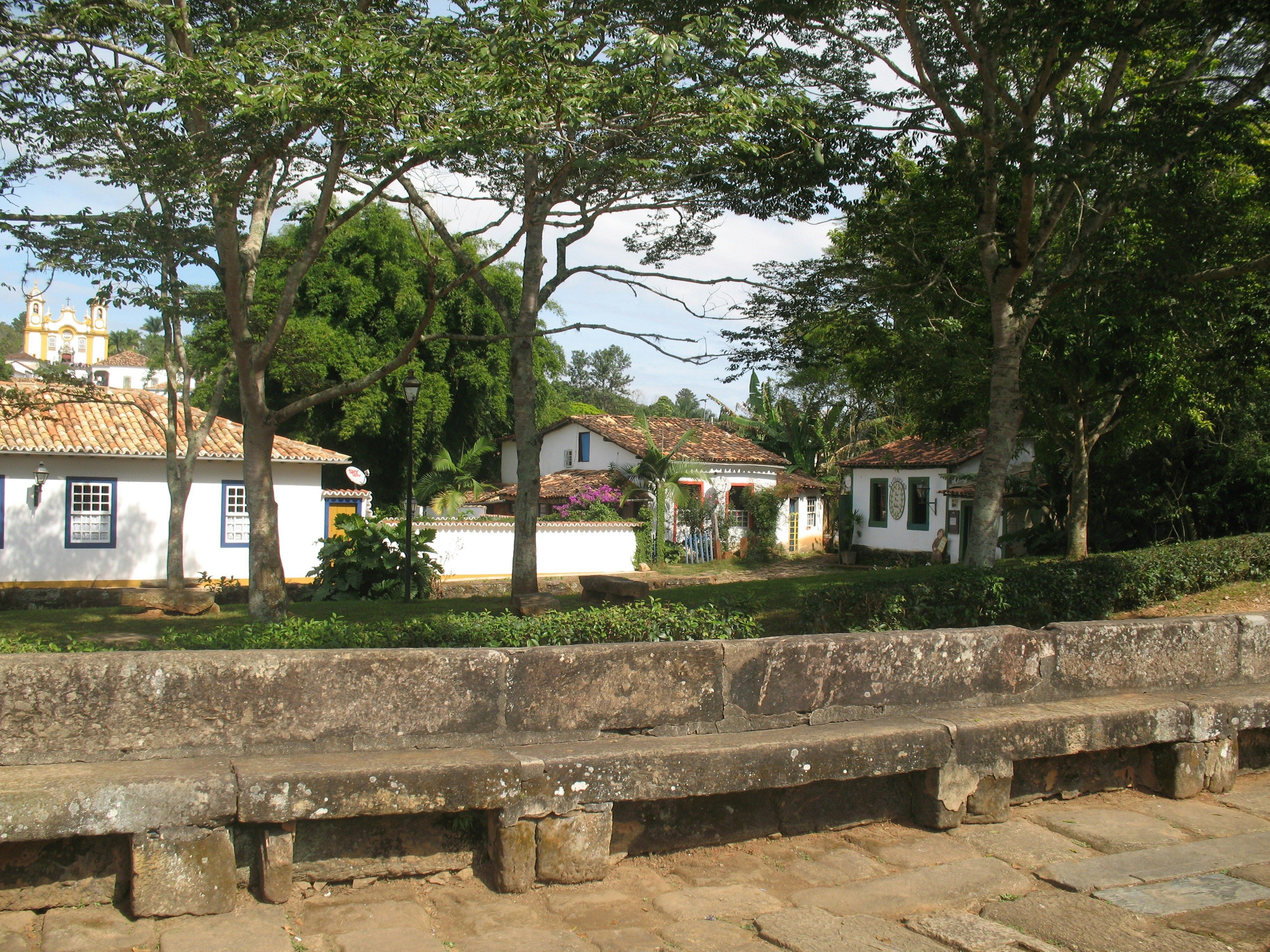 banc en pierre maisons blanches et arbres