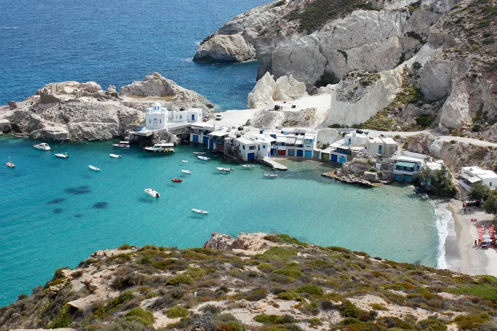boats docked in a rocky bay in Milos