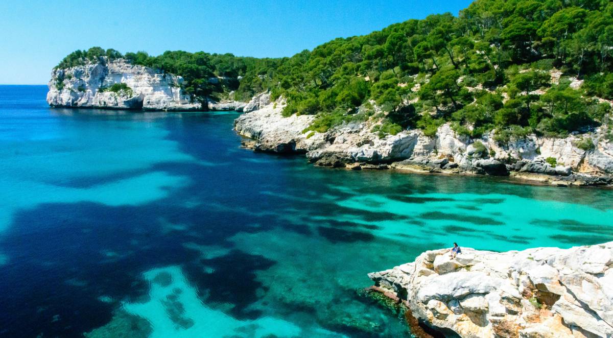 Cala Macarella en Menorca con aguas turquesa y acantilados verdes
