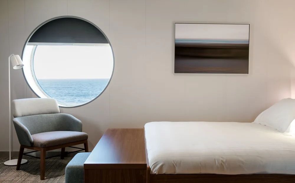 Cabina moderna con cama doble y ventana al mar en un ferry de Brittany Ferries