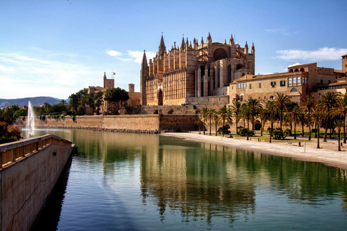 Vista panorámica de la Catedral de Palma de Mallorca reflejada en el lago del Parc de la Mar en un día soleado