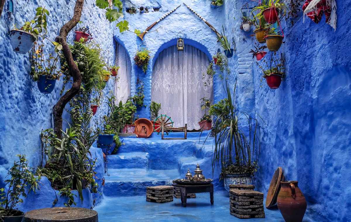 Calle típica de Chefchaouen con fachadas azules y decoración tradicional marroquí