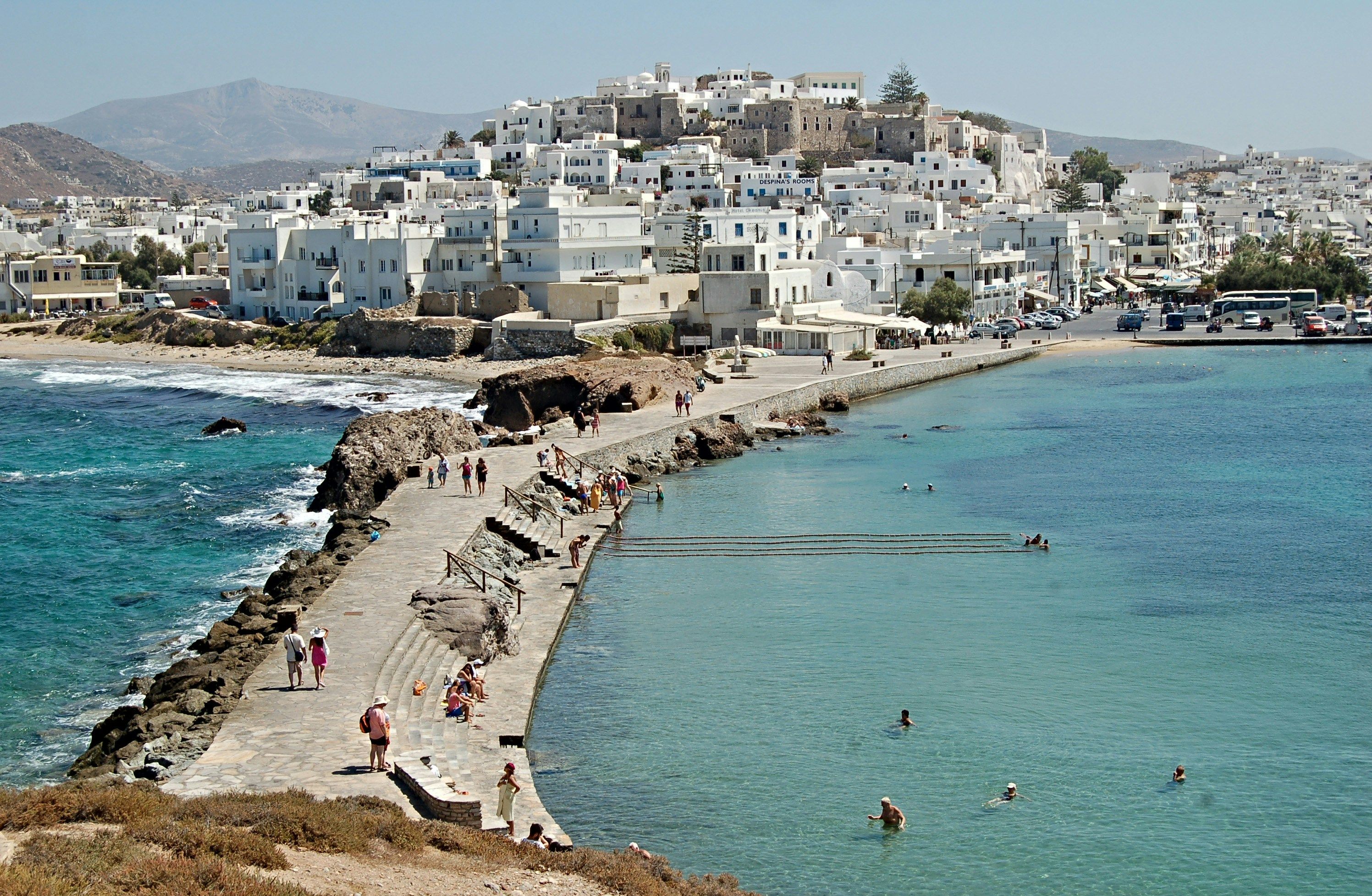 people walking along a pier towards Naxos town