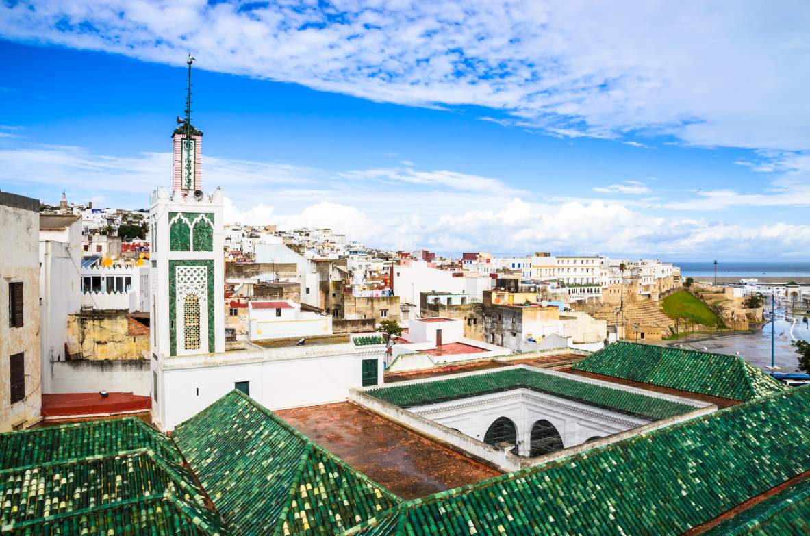Panorámica de la medina de Tánger: tejados verdes, un minarete y el litoral marino al fondo
