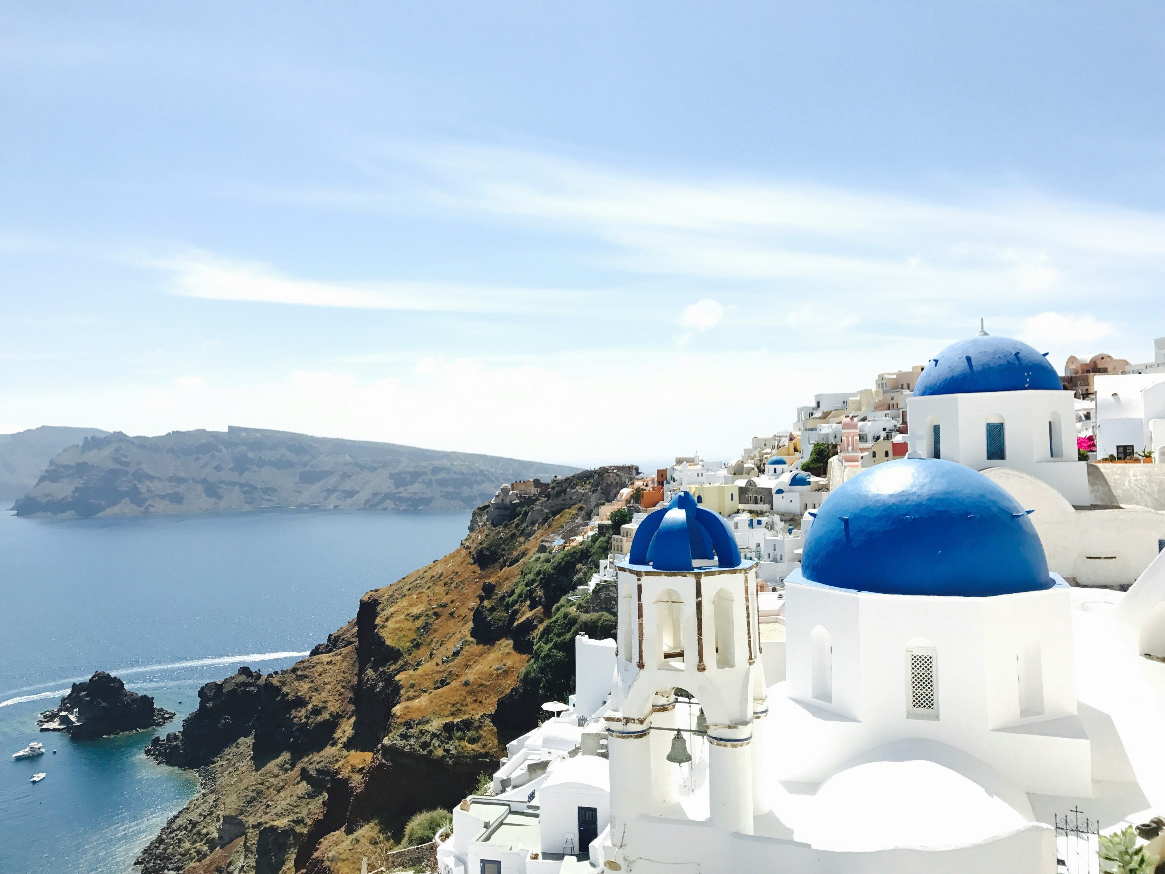 blue and white buildings on a cliff in Santorini