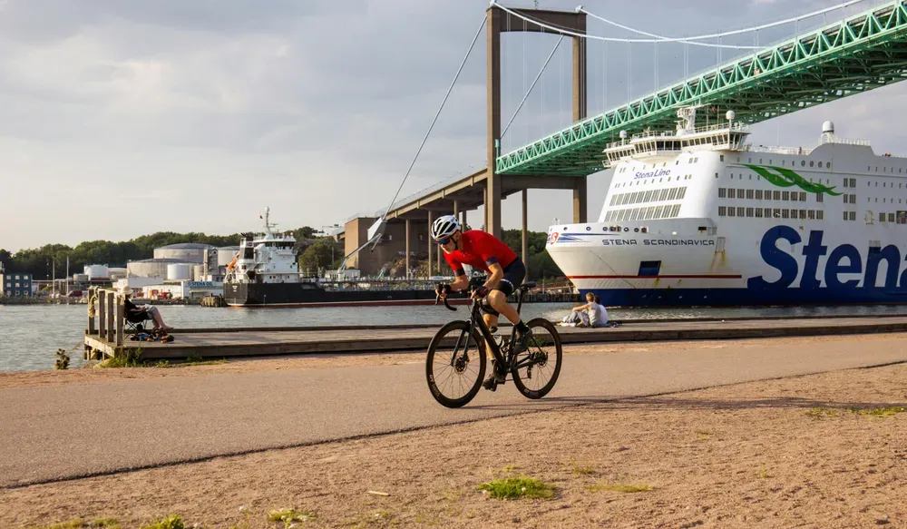 cyclist riding past a ferry in Gothenburg