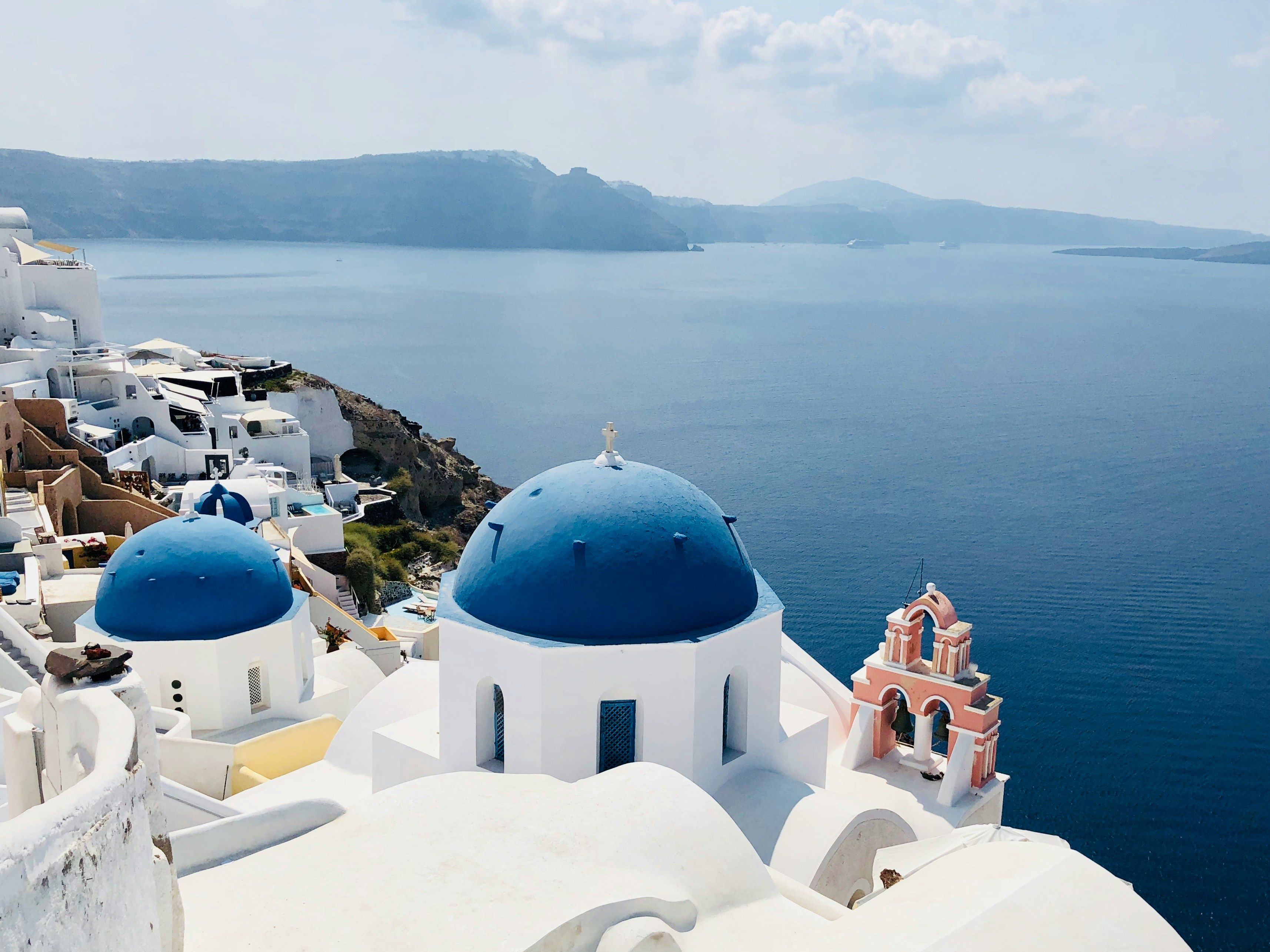 blue and white buildings on cliff edge in Santorini