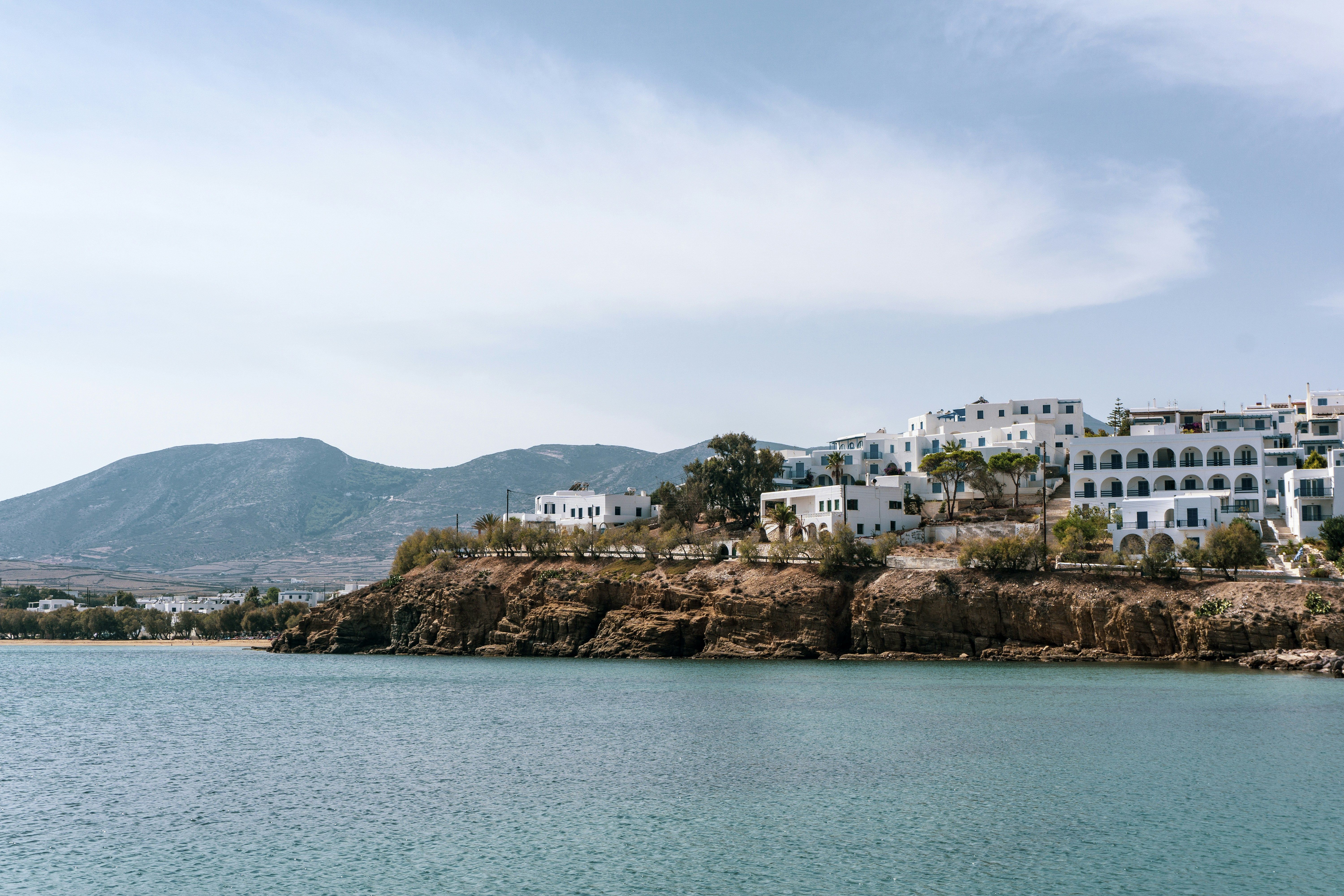 whitewashed buildings on a hill by the sea