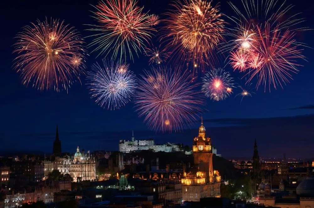 Fuegos artificiales iluminando el cielo sobre el Castillo de Edimburgo en Nochevieja.