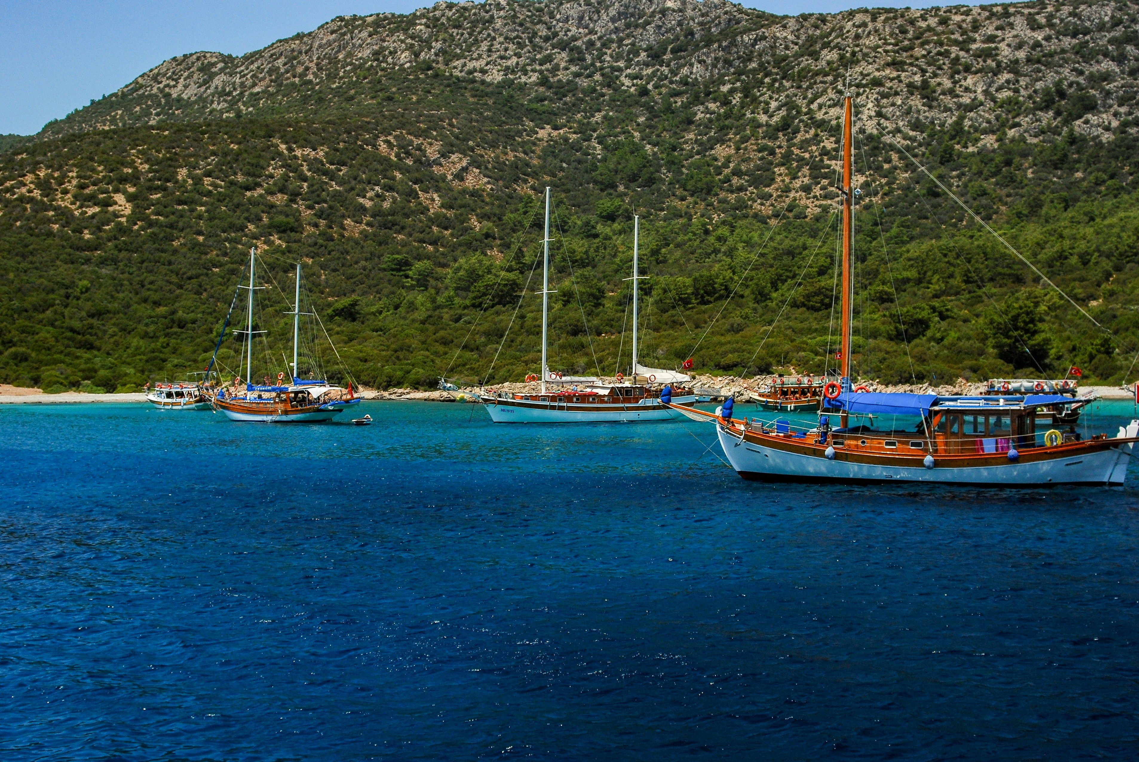 boats in the sea with green hills behind