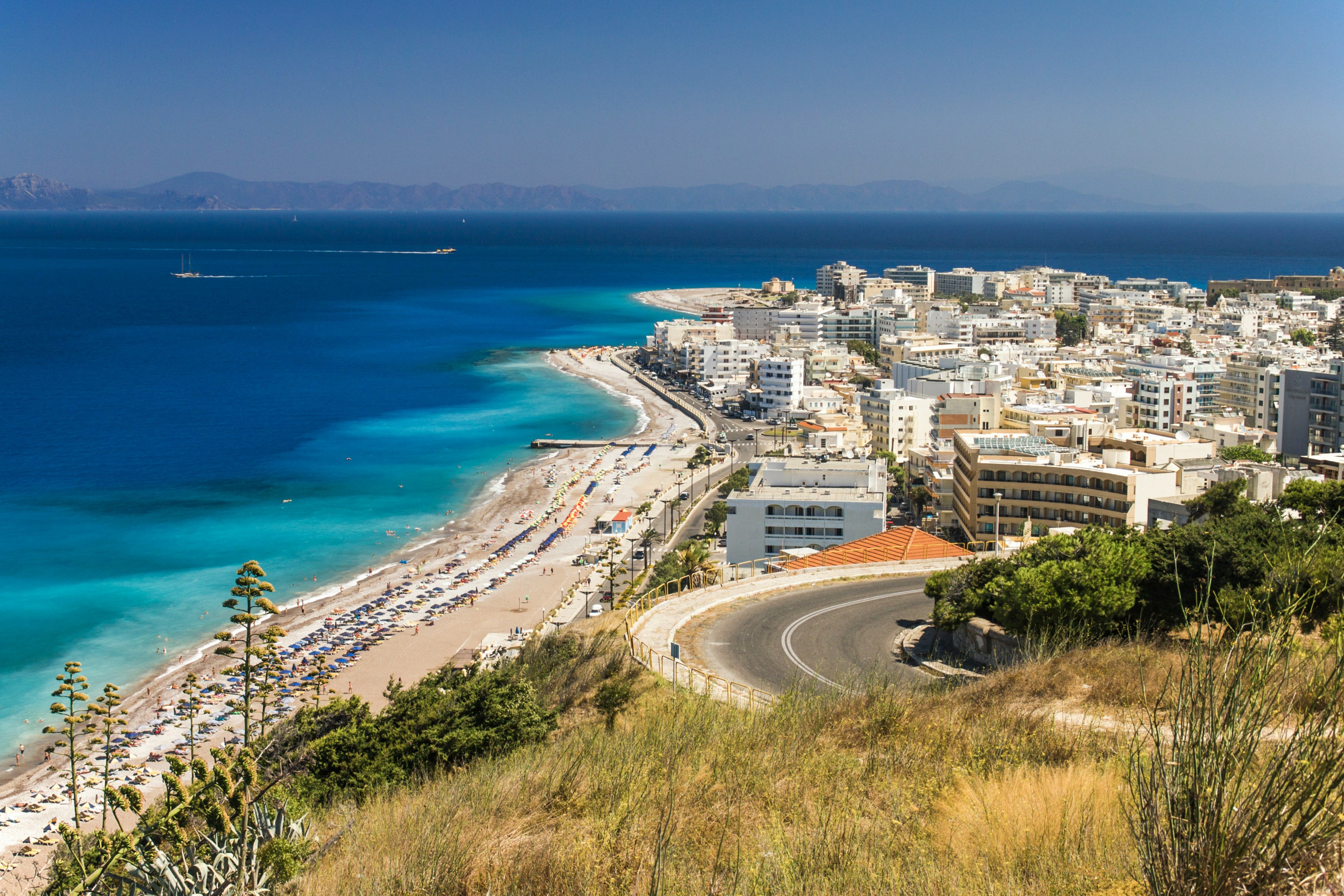 white buildings next to a sandy beach in Rhodes