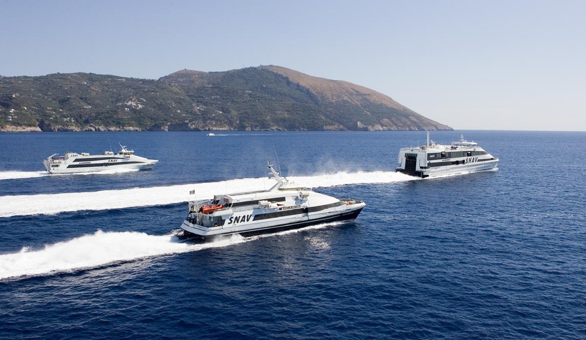 ferries del operador Snav navegando por las aguas turquesas del Golfo de Nápoles con una montaña de fondo