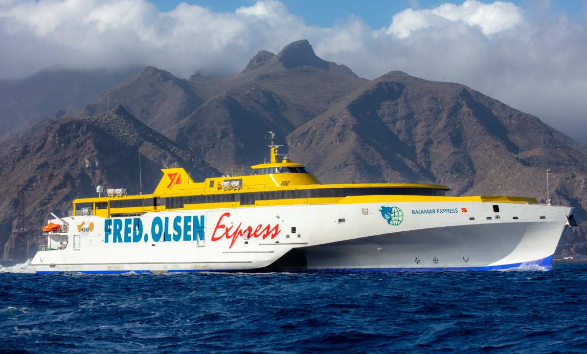 Ferry de Fred. Olsen Express navegando cerca de la costa montañosa de Tenerife, Islas Canarias.