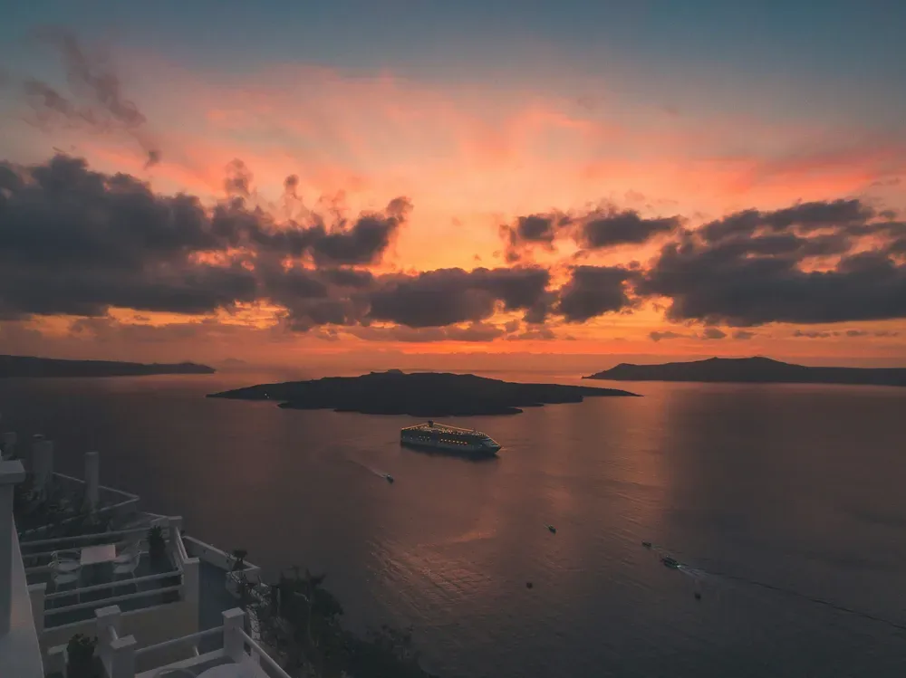 ferry in the sea off the coast of Santorini at dusk