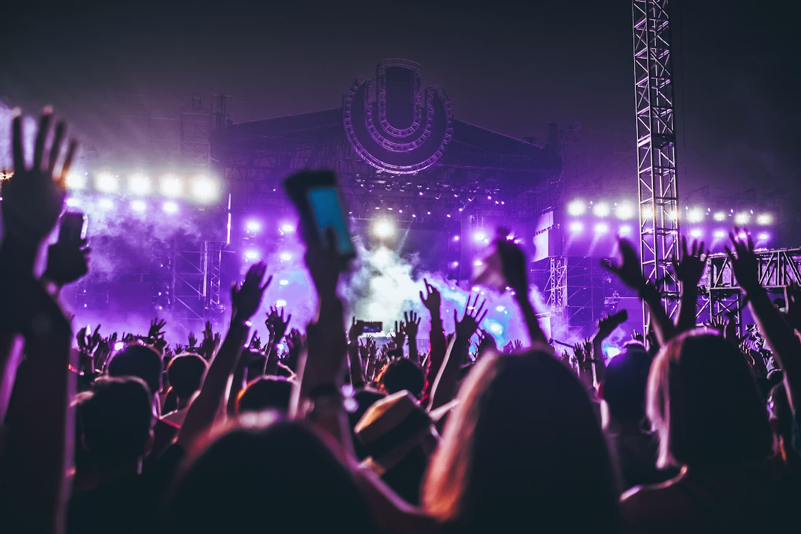 A festival stage illuminated with purple lights at night