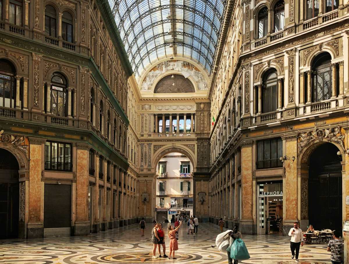 Interior de la Galería Umberto I en Nápoles, Italia, con su cúpula de cristal y arquitectura clásica, uno de los lugares más emblemáticos que visitar antes de tomar el ferry