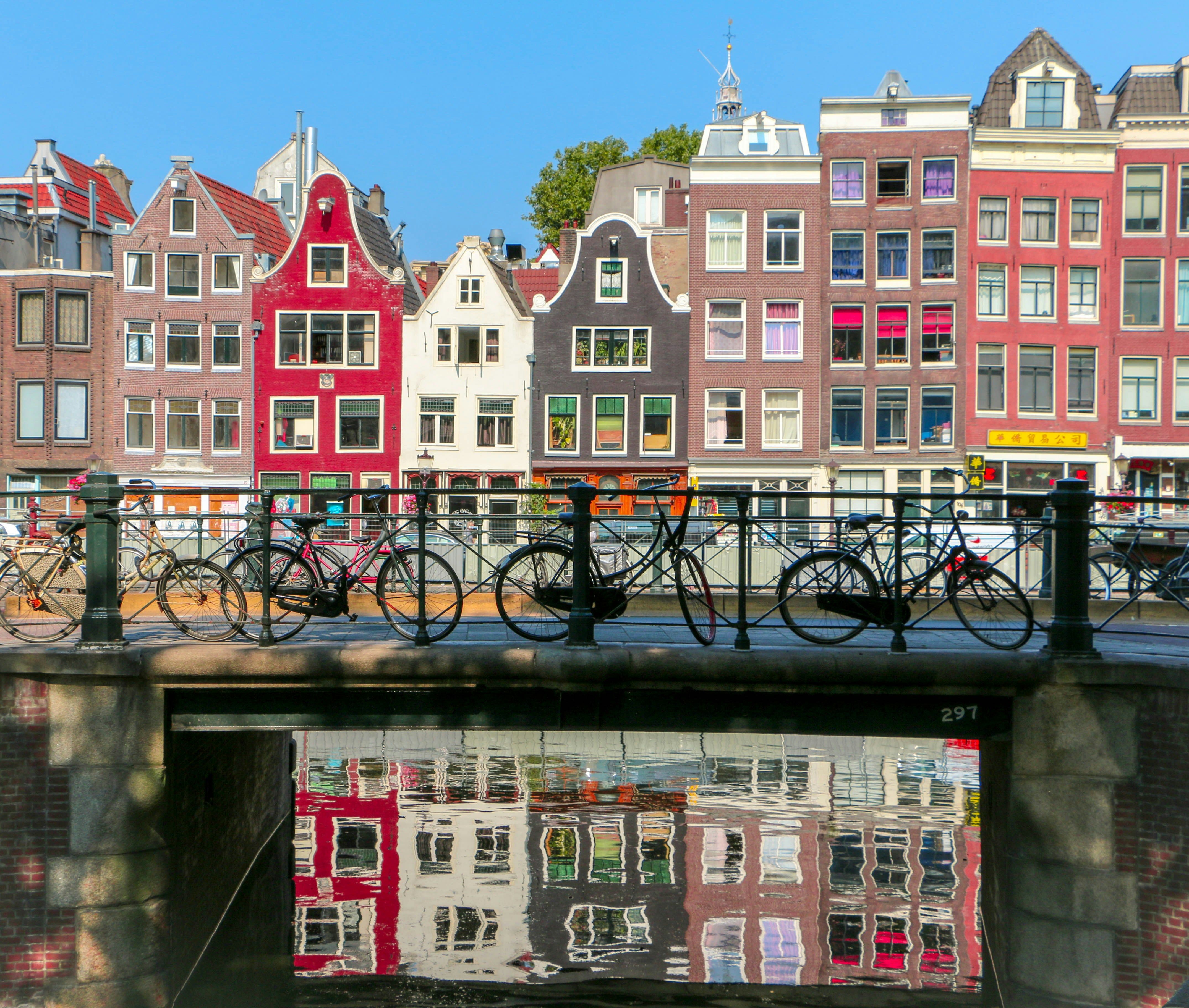 bicycles on a bridge with a row of colourful houses behind