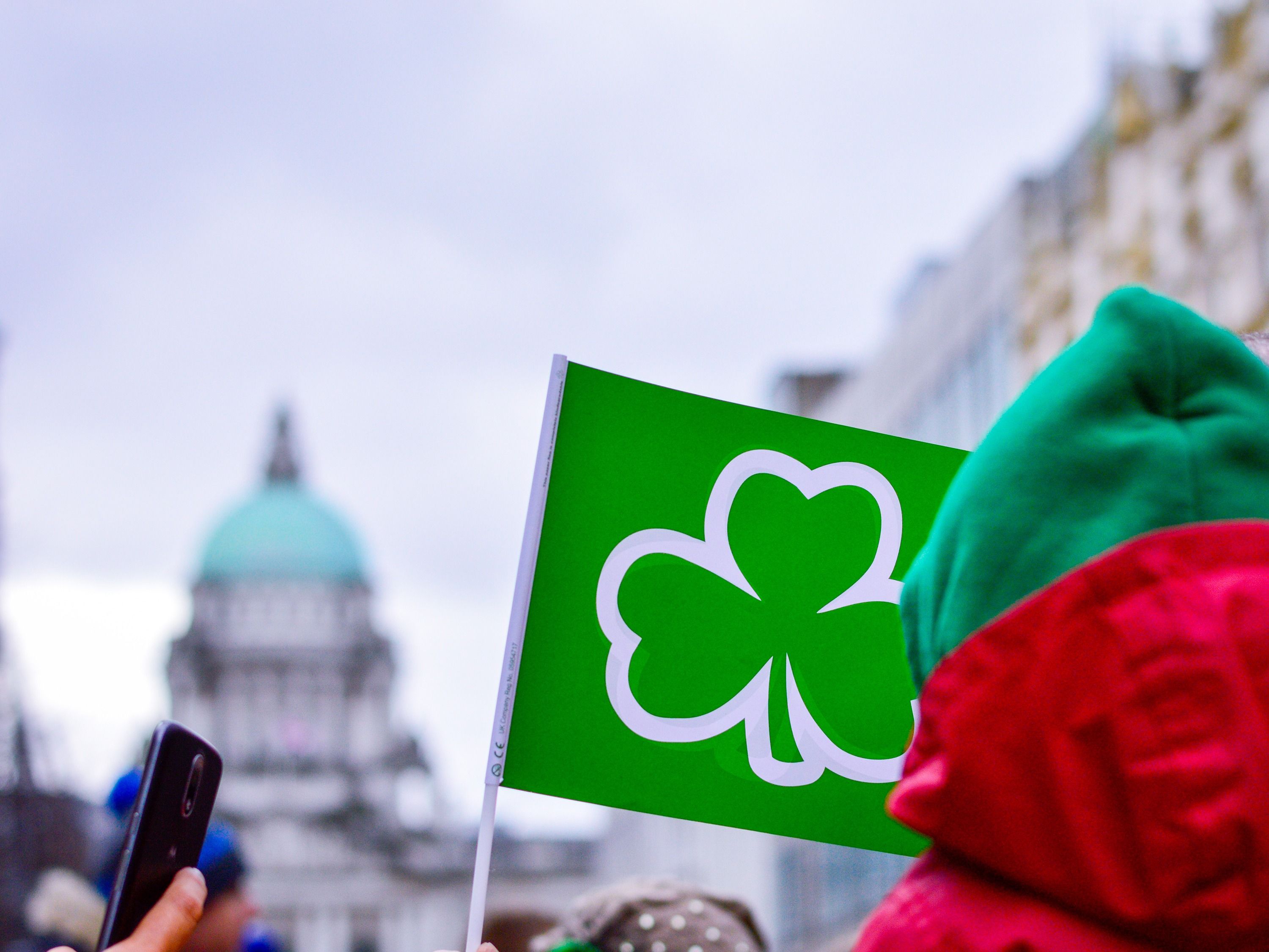 green flag with shamrock in front of Belfast City Hall