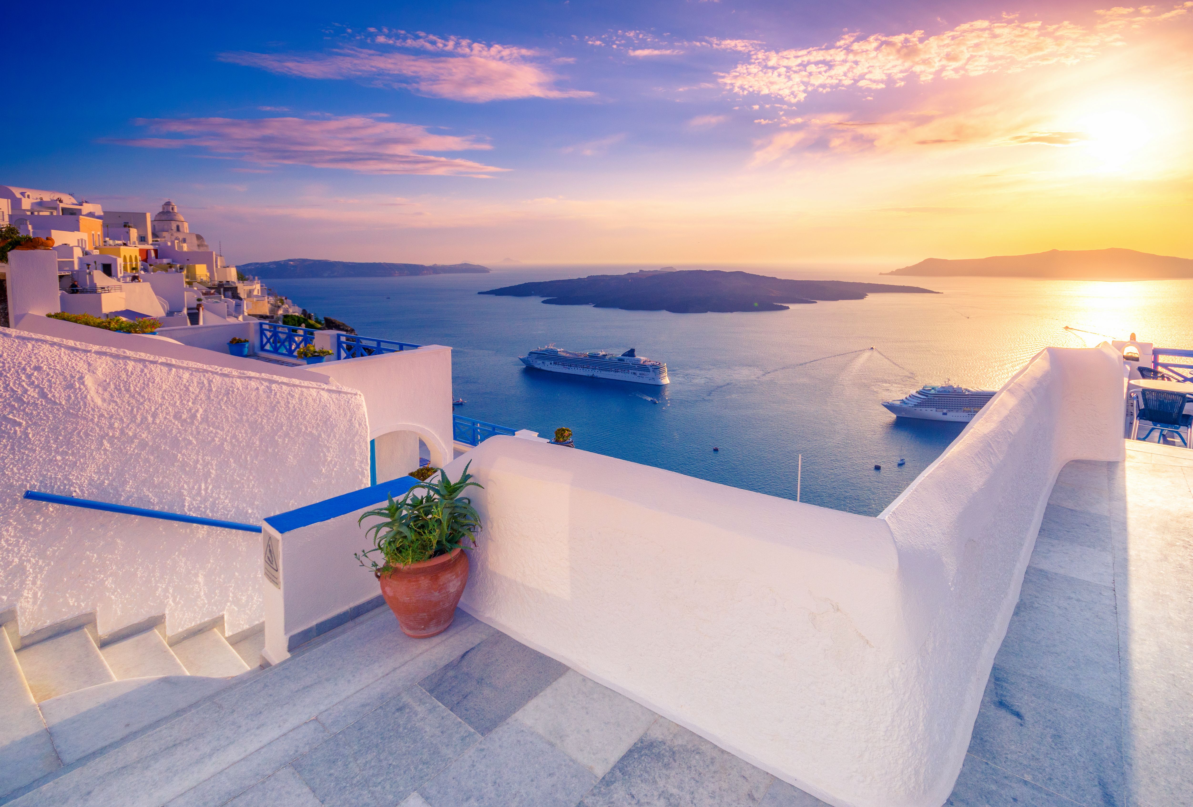ferry in sea off the coast of Santorini at sunset