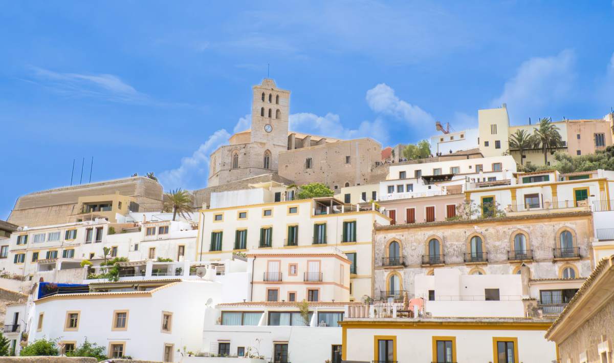 Vista de Dalt Vila en Ibiza, con sus casas blancas y la catedral al fondo bajo un cielo despejado.