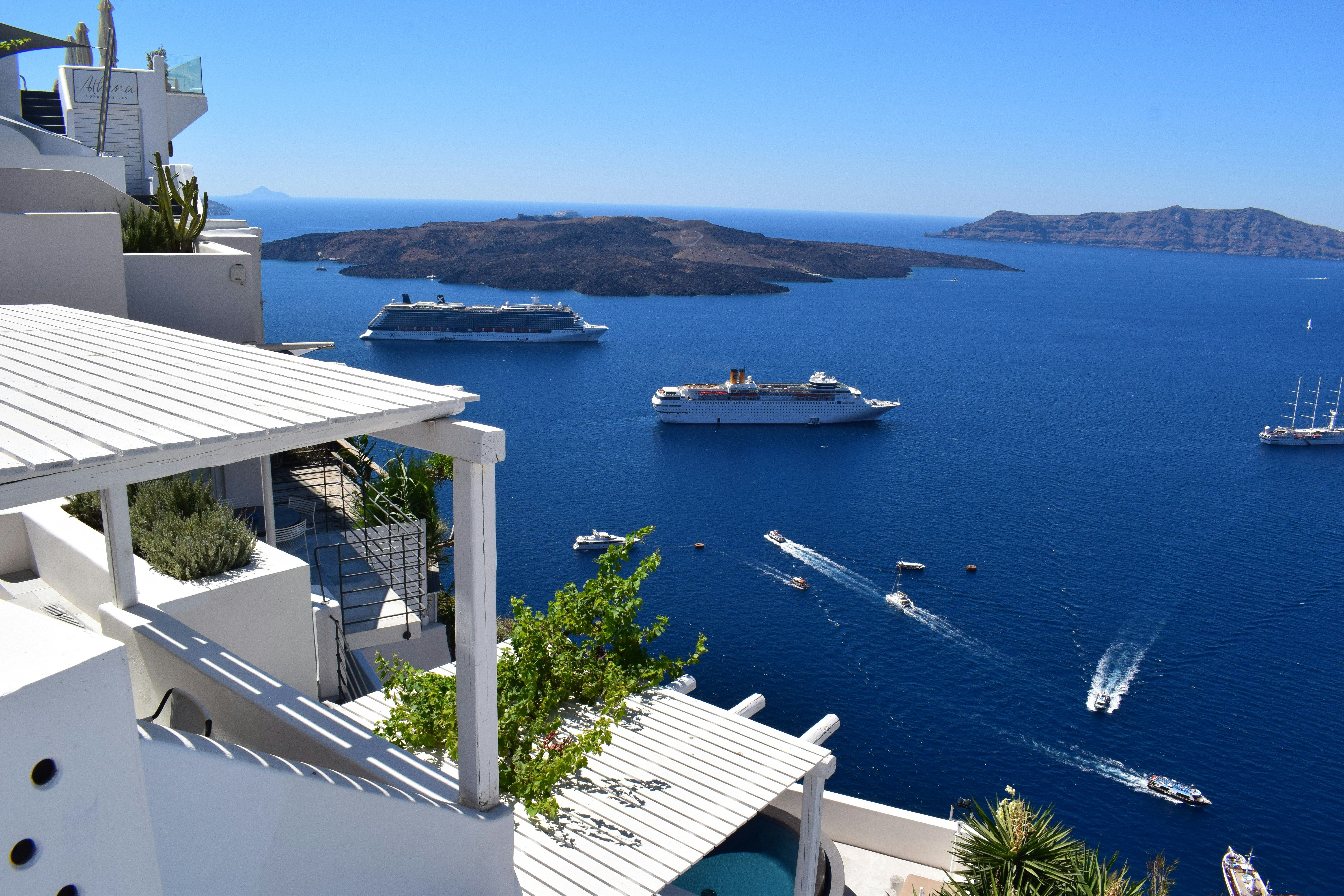 cruise ships in the sea next to Santorini