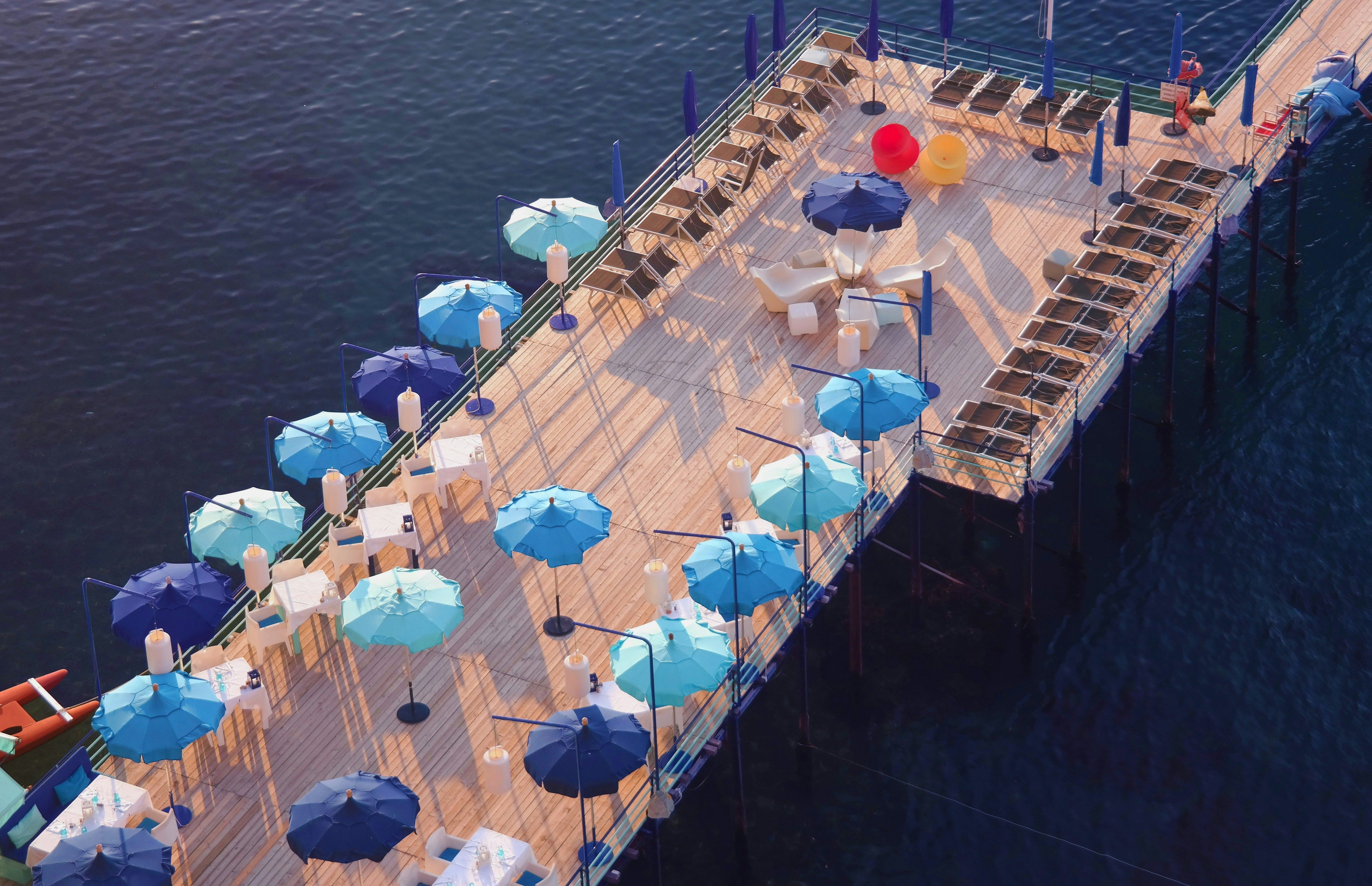parasols bleus sur jetee en bois dans la mer