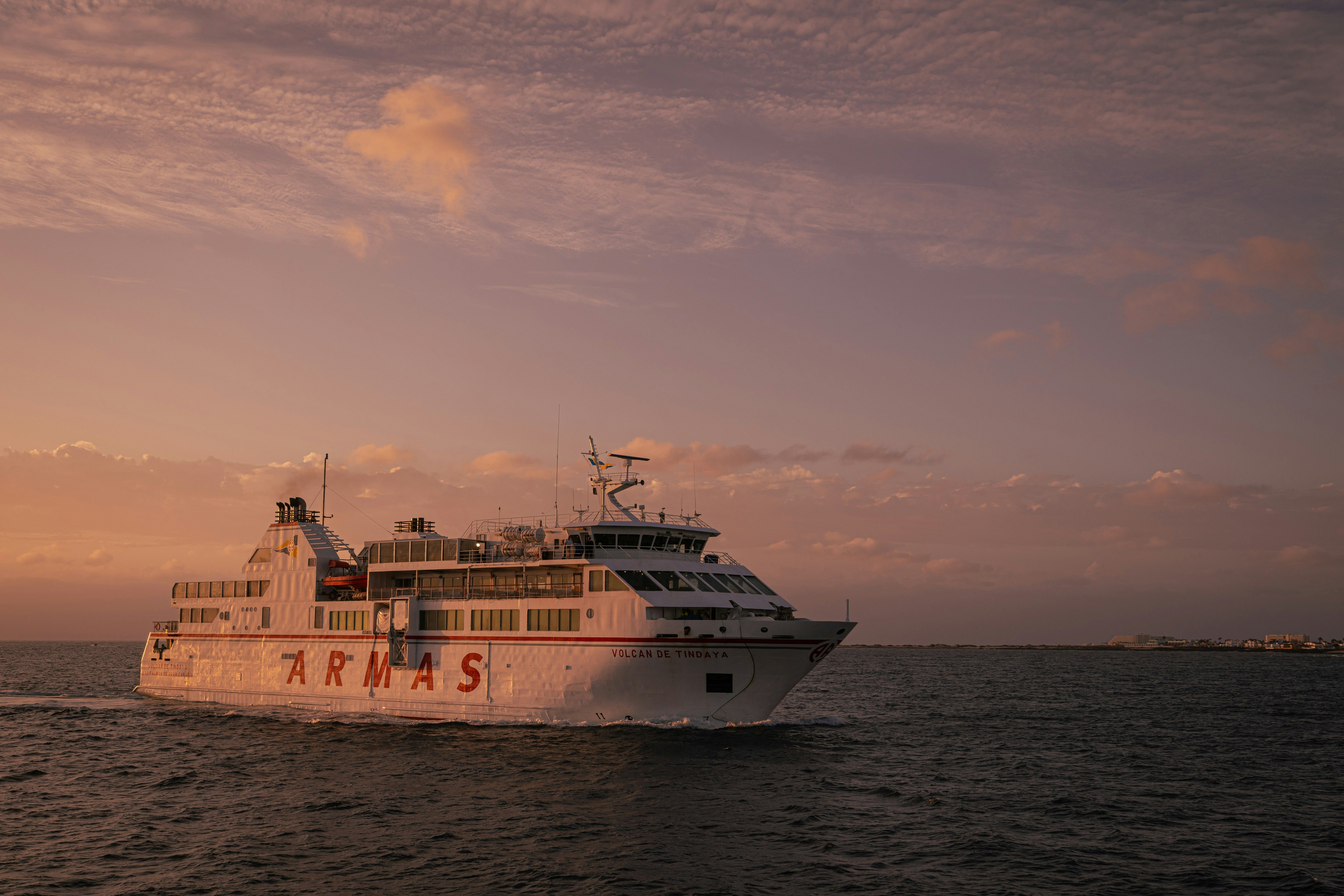 Ein Schiff von Naviera Armas fährt bei Sonnenuntergang auf dem offenen Meer.